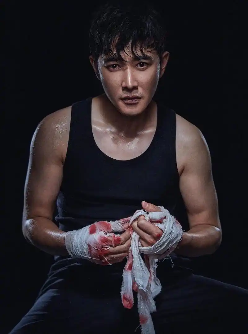照片中罗晋身穿黑色背心,头发微湿,绷带沁血,手臂肌肉被汗水渗透后更
