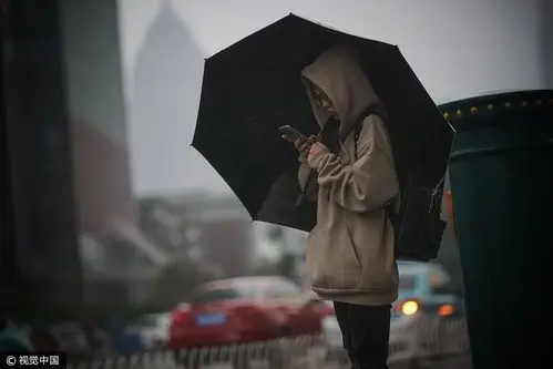 天津节后首日遭遇大风大雨又大雾 行人街头艰难前行