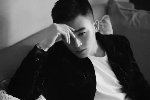 "照片中,欧豪身穿黑色丝绒外套,斜坐在沙发上,看起来十分帅气.