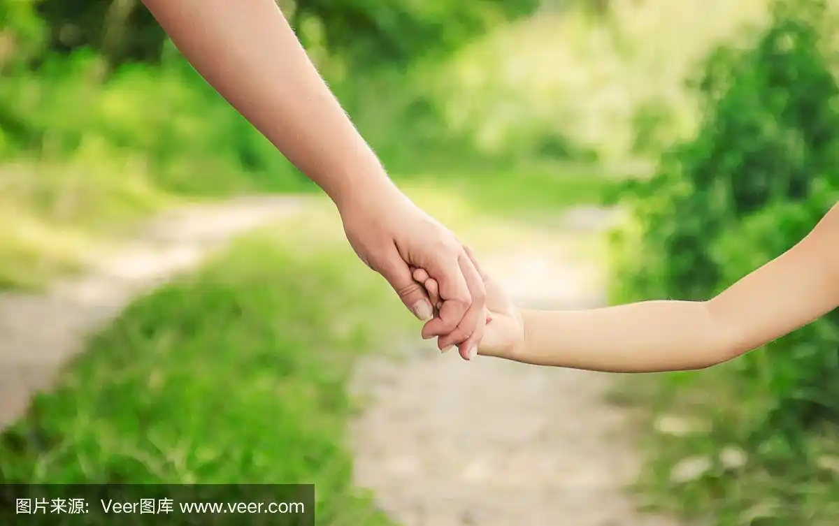 妈妈和女儿手牵着手走在路上.