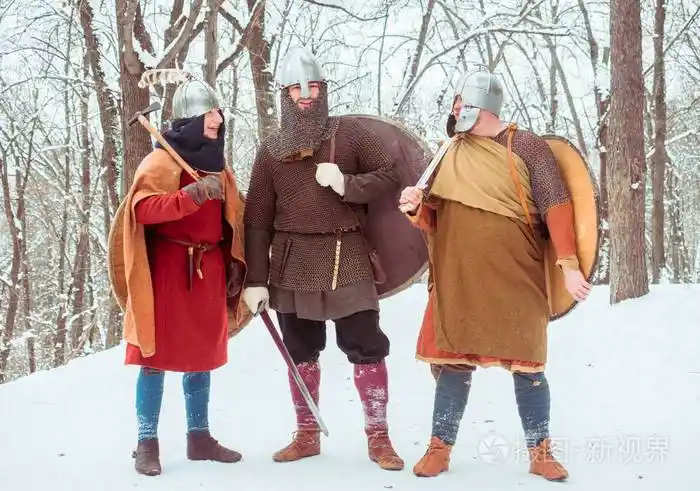 小组武装的中世纪战士与盾牌, 剑, 长矛在冬天森林里