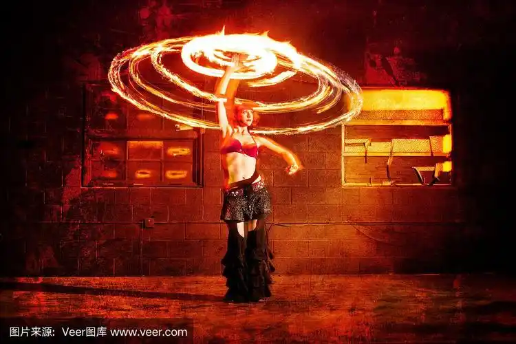 美丽的女人旋转火焰和跳舞