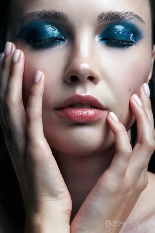 特写镜头的女性与手近脸的宏观肖像.有晚上美容化妆的女人.