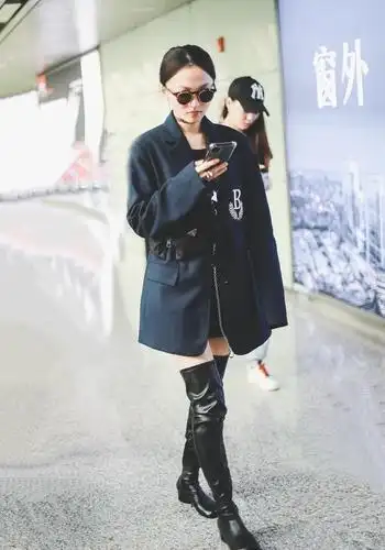 张韶涵身穿黑色束腰西装,脚踩长靴,尽显酷炫气质