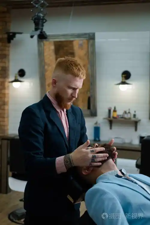 男客户被理发师理发.高级男子在理发店拜访发型师.理发剪和剃须刀.