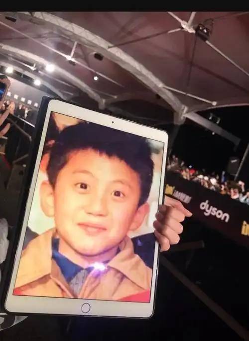 11月17日金马奖红毯上,有一位粉丝高举着晒有邓超小时候照片的