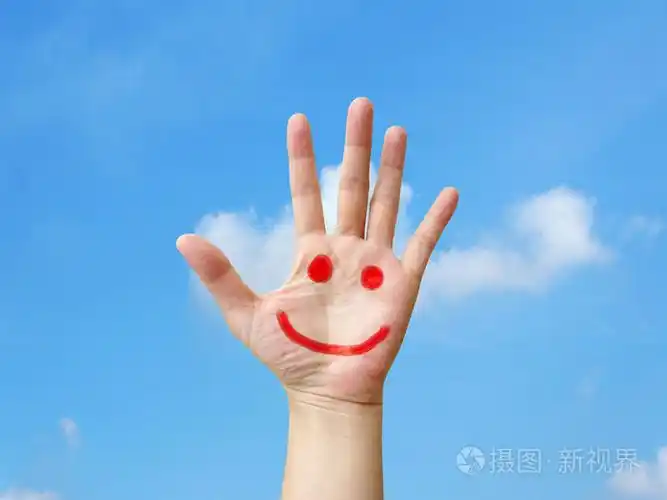 被绘上张开的手蓝蓝的天空背景下的微笑