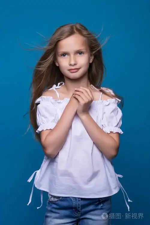 可爱小女孩微笑着摆在工作室里的肖像