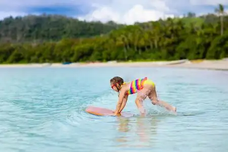 儿童在热带海滩冲浪. 亚洲的家庭暑假. 孩子们在海水中游泳.