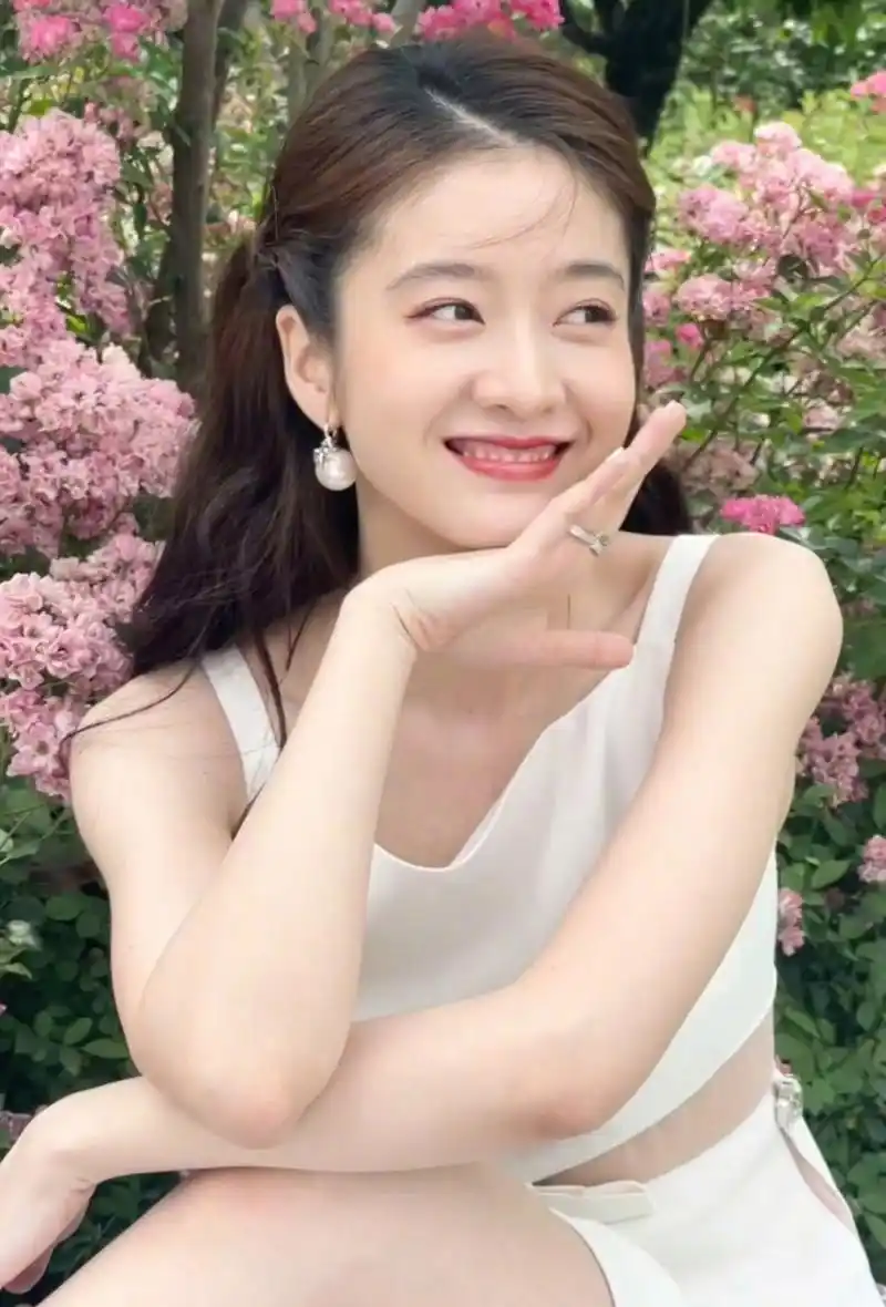 张雪迎晒营业照清新又阳光,白裙子太有夏天的感觉了,配合身后的粉色