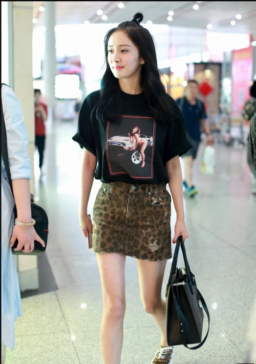 杨幂身穿黑色t恤豹纹短裙现身机场 扎着小揪揪显得活力四射