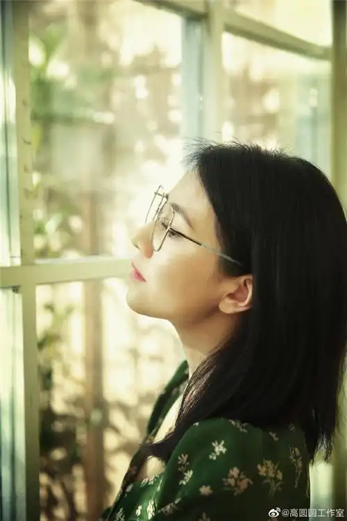 高圆圆戴着银边框架眼镜 身穿绿色碎花裙 侧颜优雅