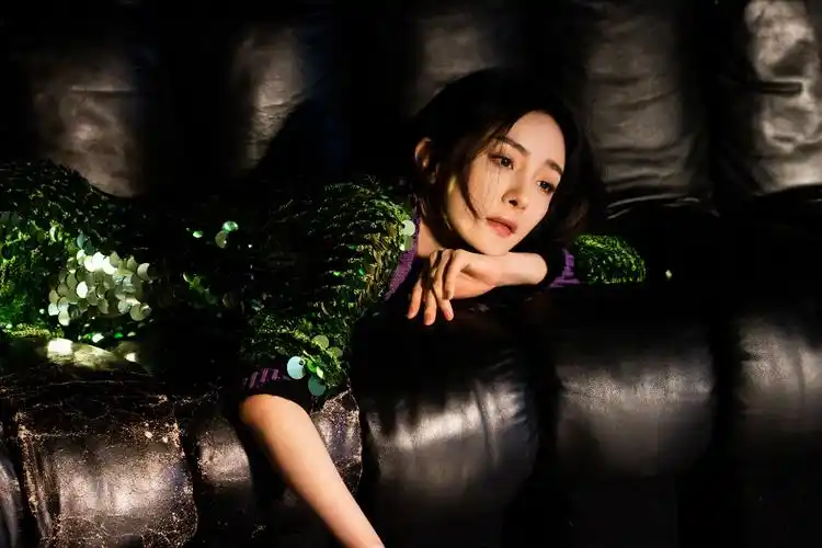 照片中,杨幂穿着带有亮片装饰的薄纱裙,隐约露出完美腿部线条,a字连体