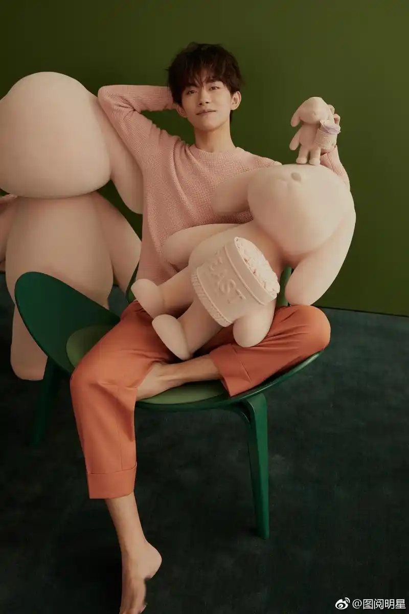 一组易烊千玺最新写真,照片中易烊千玺赤脚出镜,与花朵玩偶相伴,童趣