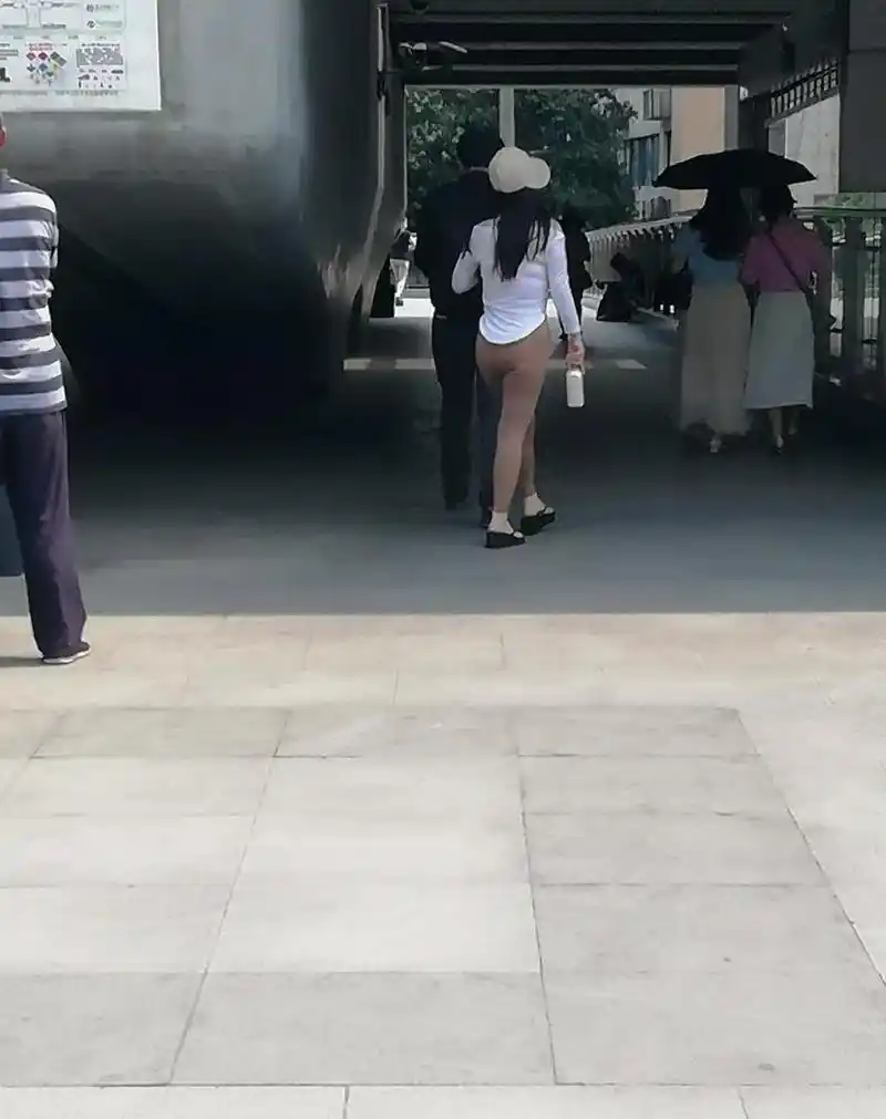 一位女士穿着很薄的紧身裤从旁边走过,都勒出了一条缝,回头率杆杠的