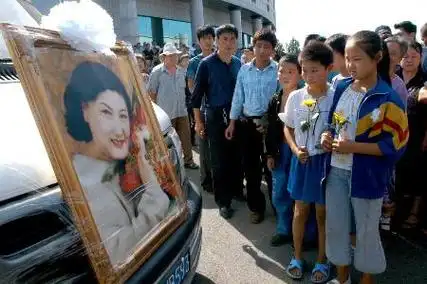 长春万人送别高秀敏      8月20日,几名小学生在灵车前向高秀敏告
