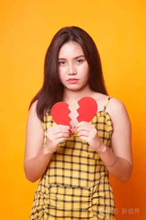 美丽的年轻亚洲女人心碎的黄色背景