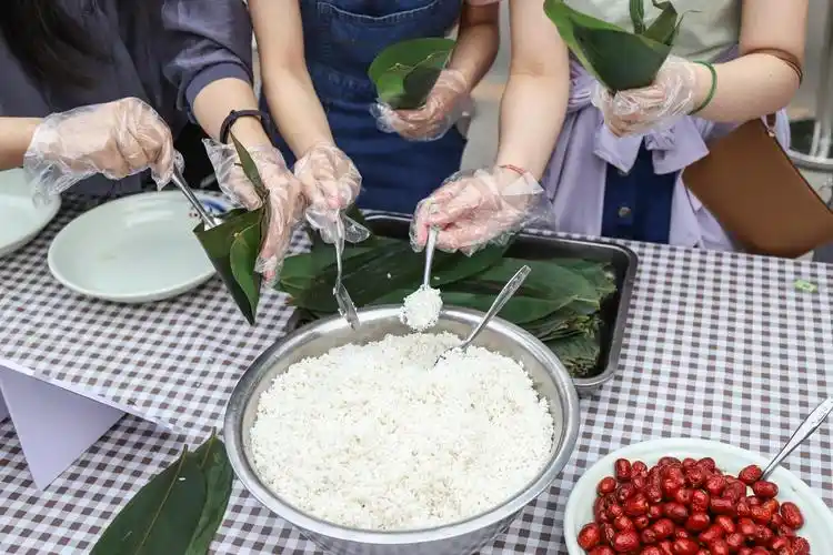 (同学们自己动手包粽子 摄影 郭宏政)在昌平校区的活动现场,饮食服务