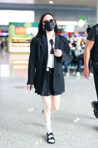 张韶涵穿搭一件白色的衬衫,打着黑色的领带,外搭是一件黑色的西装外套