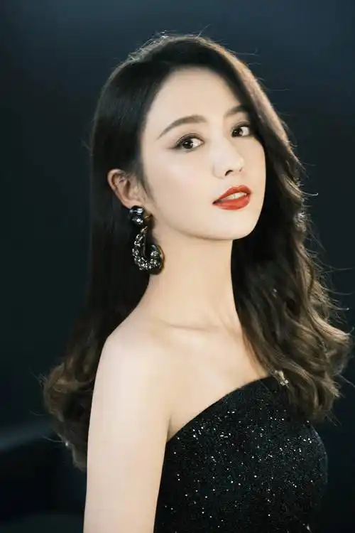 照片中的佟丽娅身穿亮闪黑色长裙,一头大波浪长发性感撩人,气质满分!