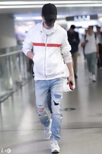 罗晋戴棒球帽穿白卫衣搭配破洞牛仔裤现身机场,戴口罩低着头走路