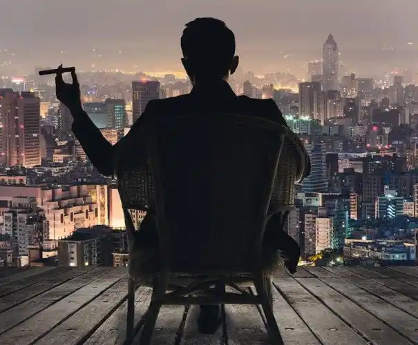 黄昏时看着城市坐在椅子上商人的身影