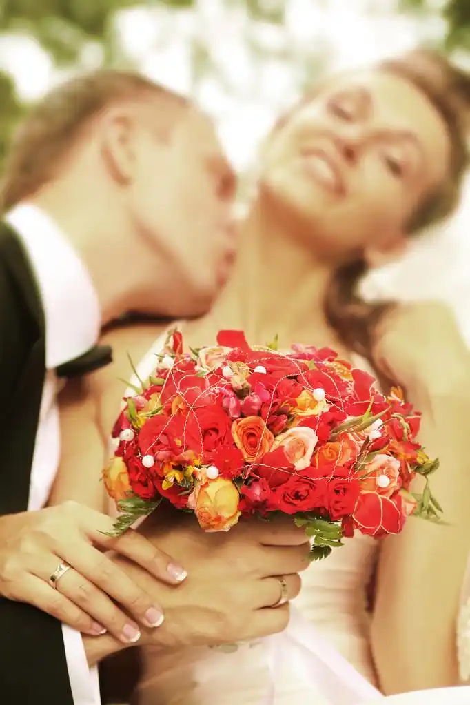 亲亲,丈夫亲吻他的妻子 (焦点的花束)