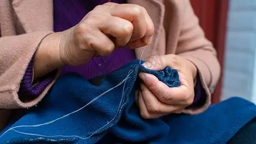 人文摄影照片_母亲缝补衣物母亲节妈妈家里制衣缝补摄影图配图