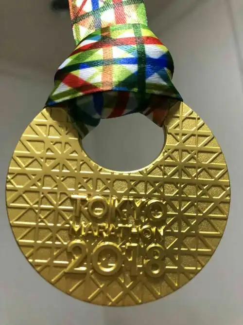 这是邱家文在2018年东京国际马拉松赛中荣获的奖牌正面.
