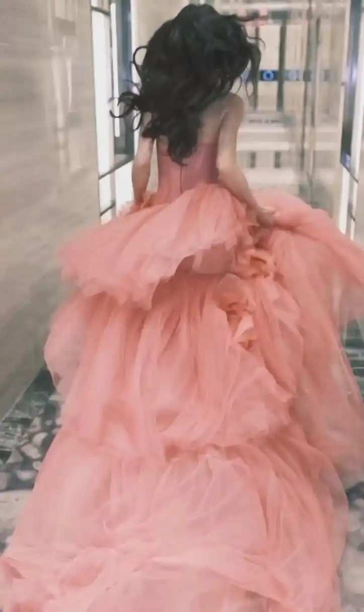 她穿着粉色长裙, 在楼道里奔跑, 在视频的最后回眸一笑.