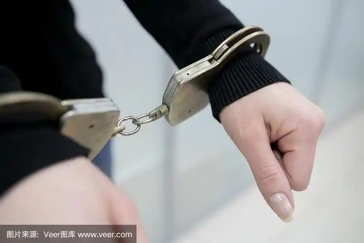 囚犯或被捕者戴手铐的手的特写.