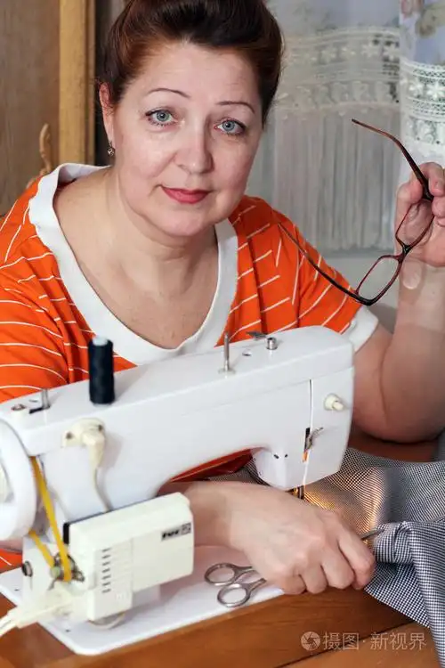 老妇人在家里缝衣服