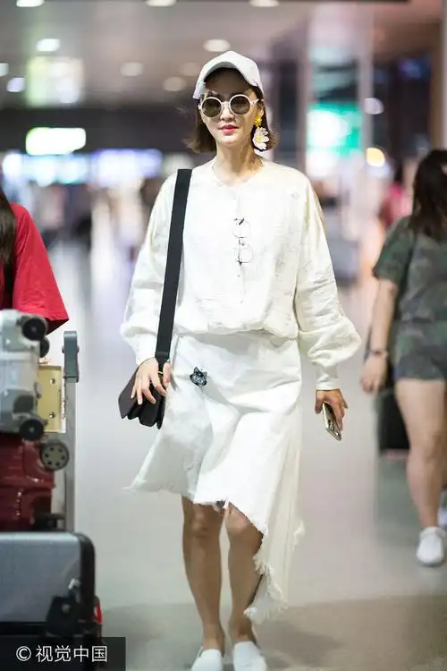 article>张歆艺穿现身机场自推行李箱 流苏帽配花朵耳环吸睛