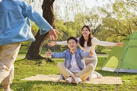 一家三口公园里野餐玩游戏图片素材