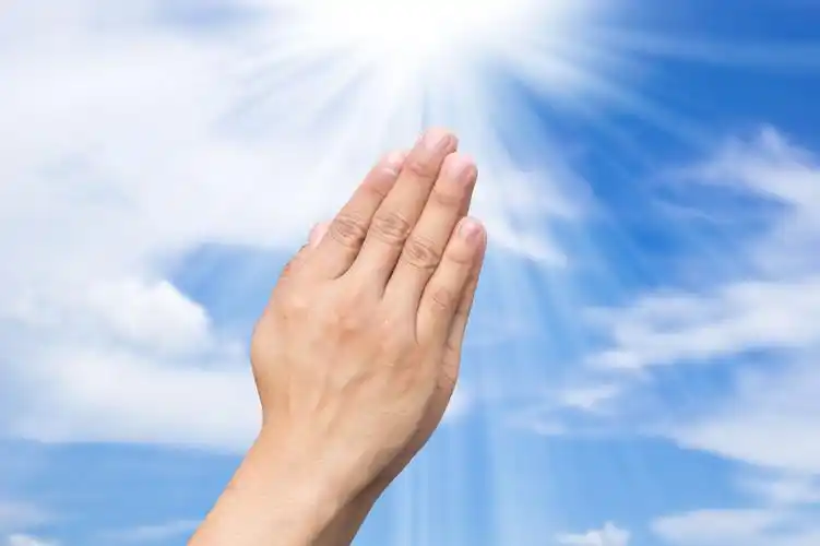 蓝天白云下祈祷的男人