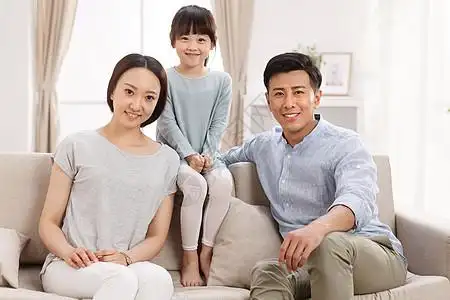 核心家庭父母双亲家庭幸福的一家三口坐在客厅里图片素材