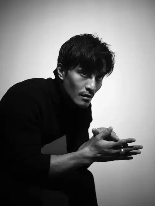 照片中丘子健身穿黑色高领毛衣,表情冷峻,眼神忧伤,加上纯黑白的调色