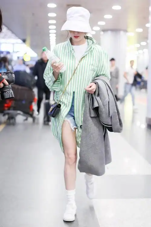 热巴渔夫帽白色超短裤现身机场,绿色条纹衬衫清爽有活力,满满的夏天的