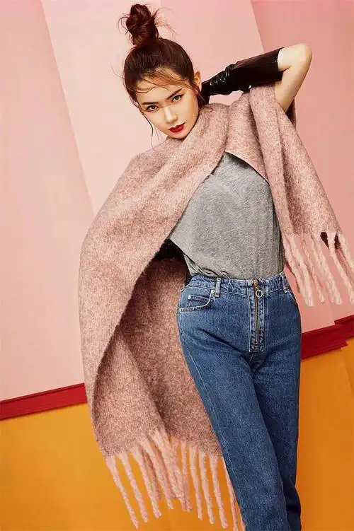 戚薇身穿灰色休闲毛衫,搭配蓝色修身牛仔裤和浅紫色披肩,充满了青春