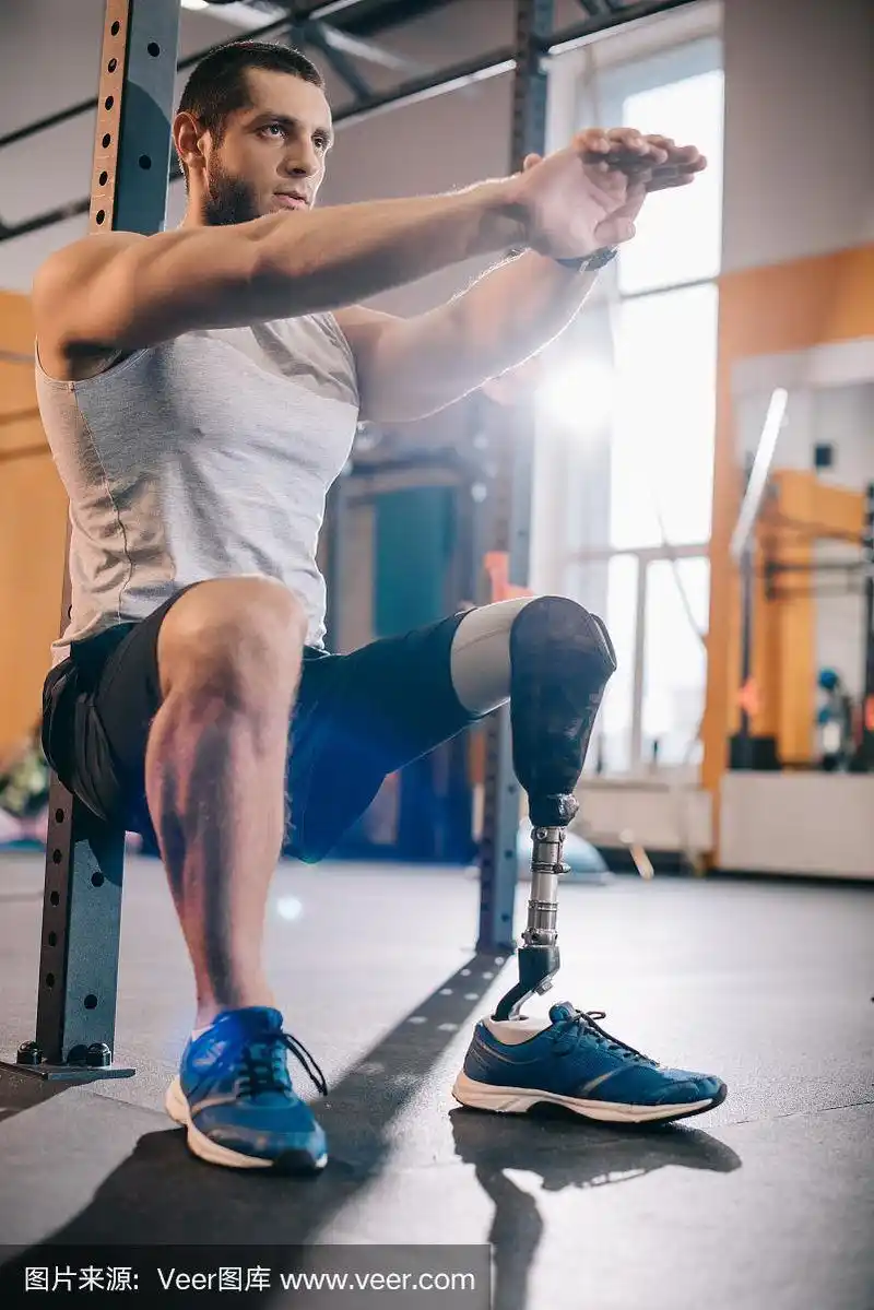 帅气的年轻运动员戴着假肢在健身房锻炼