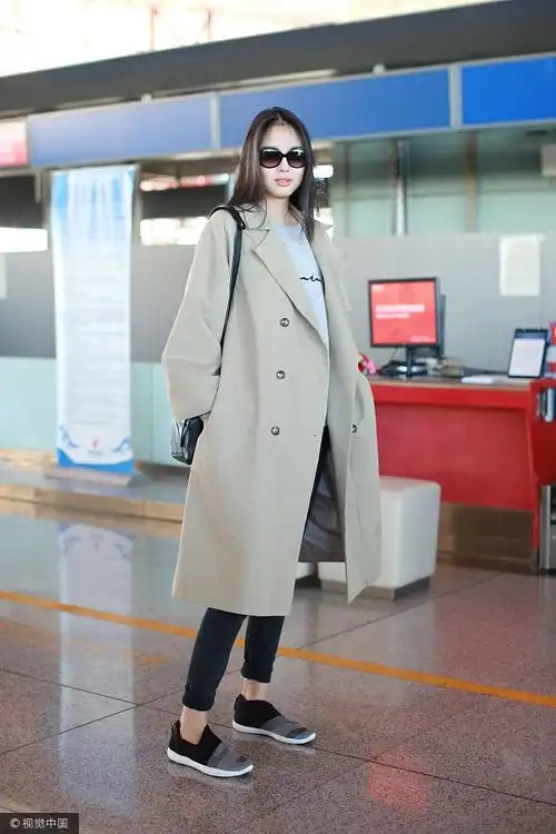 张梓琳现身机场,她戴黑色墨镜,身穿卡其色风衣,内搭灰色卫衣,肩背