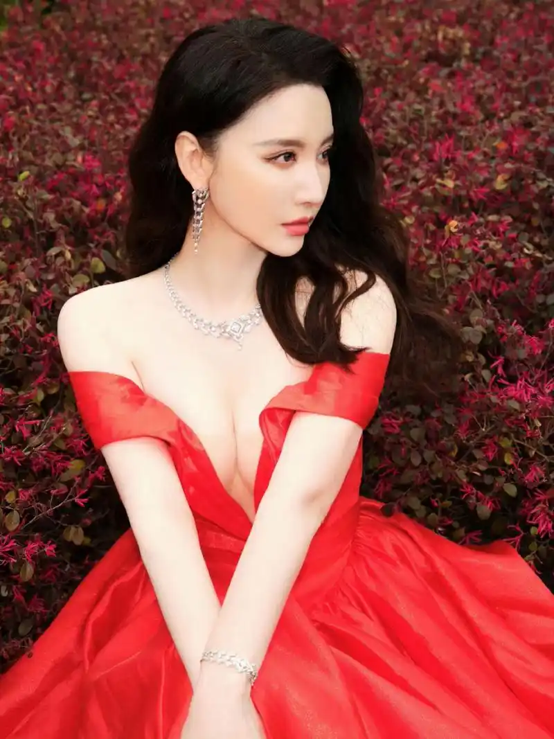 张萌# 一袭红色深v溜肩拖尾裙,肤白貌美的容颜,大波浪卷发披肩,丰腴