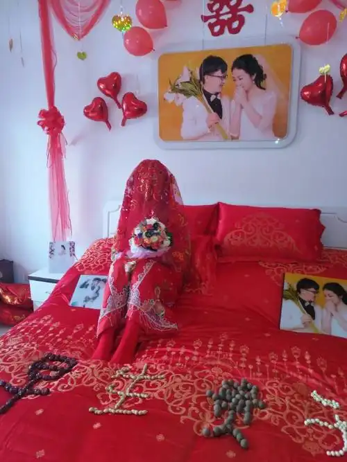 新娘坐在婚床上等待新郎携盖头,婆家人早早的在婚床上摆上对新人的