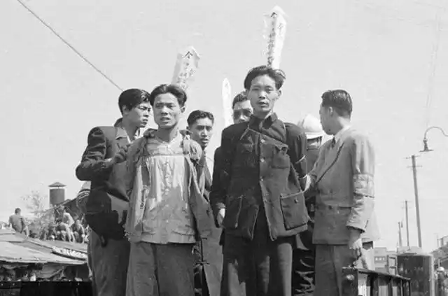 几个人即将被枪毙边上围满了大量群众很多人手上拿着一个馒头