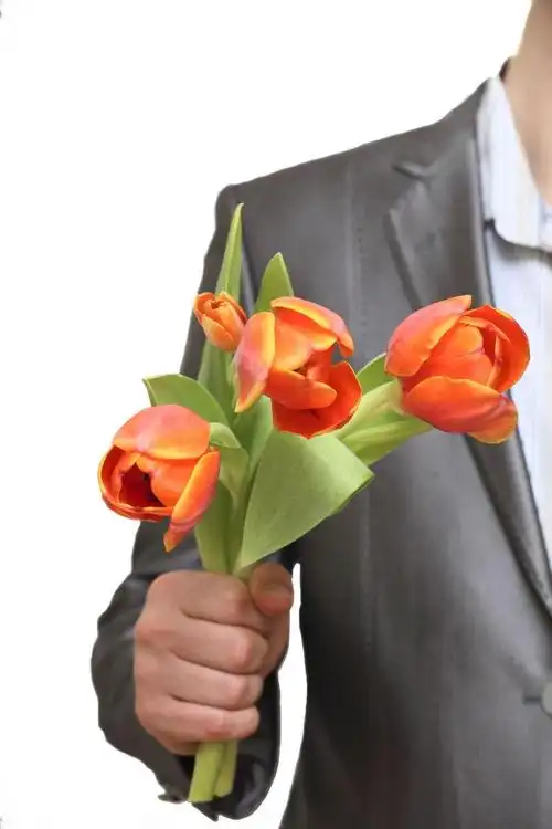 年轻漂亮的迷人男人手拿一束花束