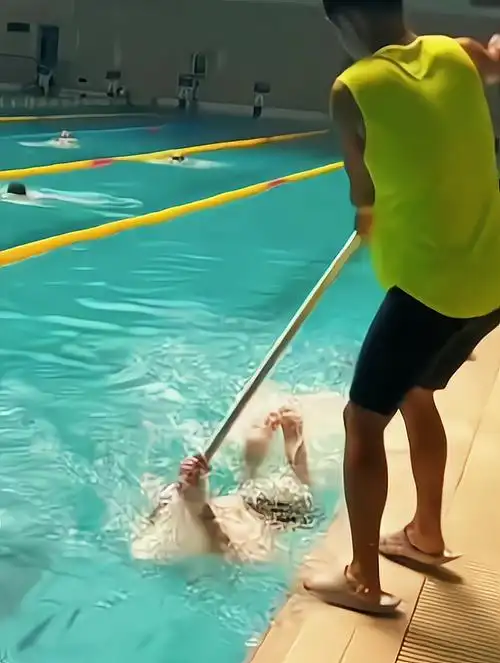 蝶泳打腿练不好,教练用杆子辅助