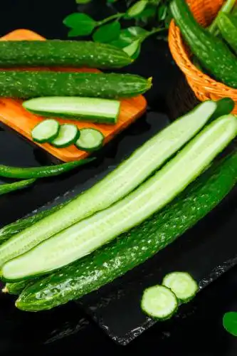切开的新鲜农家黄瓜放在黑底上