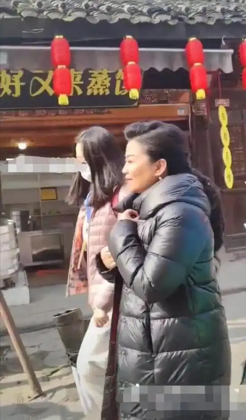 在街头拍到张也穿羽绒服驼背插袖走路是普通老人不像歌唱家