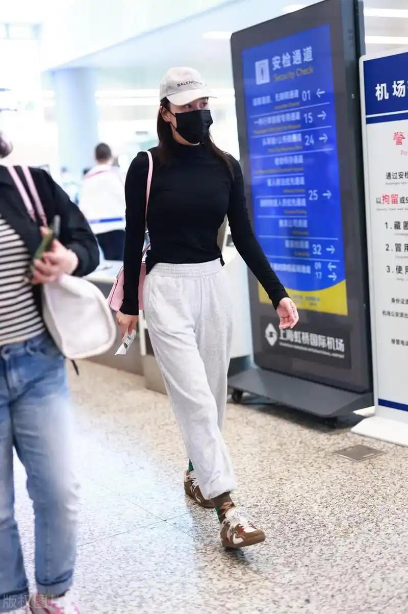 张馨予机场街拍,黑色打底衫搭配运动裤,棒球帽休闲舒适!