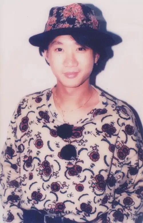 找一张黄家驹的照片,帽子和衣服有花,帽子是黑色,衣服是白色.